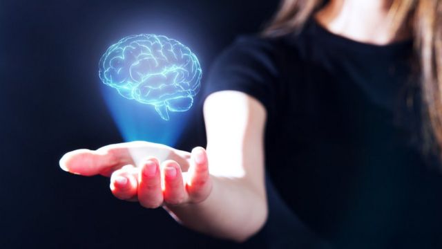 A woman with an illustration of a brain in her hand.