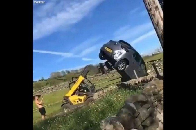 With a forklift, a farmer turns into a touring car blocking the gate