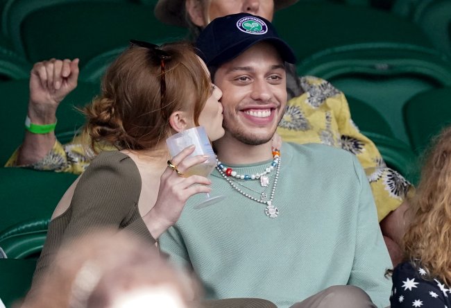 Phoebe Denivore kisses Pete Davidson on the cheek, who smiles widely.