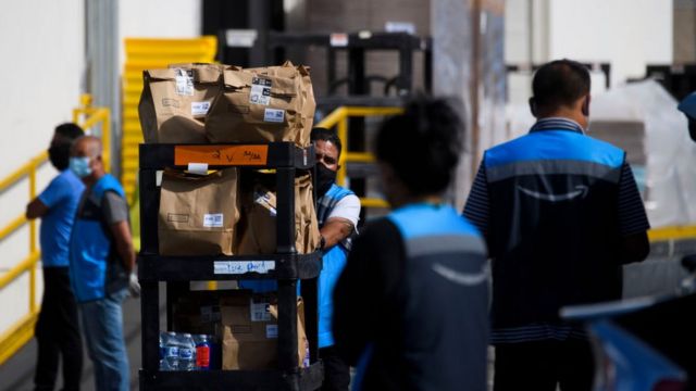 Amazon staff carrying boxes