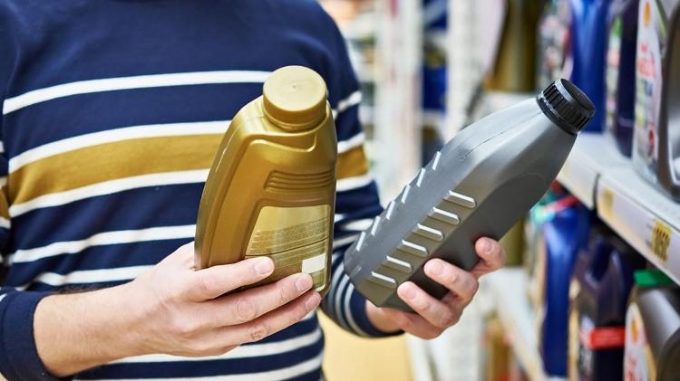 A car owner reads engine oil specifications on their packaging - Photo: Shutterstock - Photo: Shutterstock