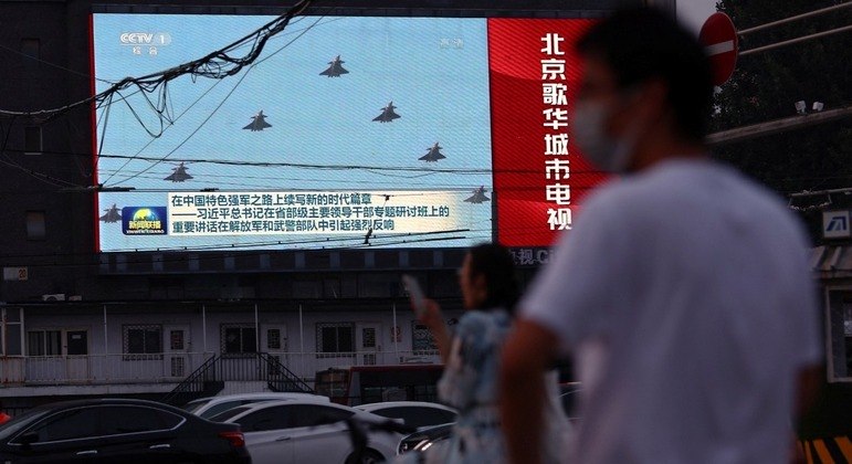 Telão exibe imagens de aviões do Exército chinês, em Pequim