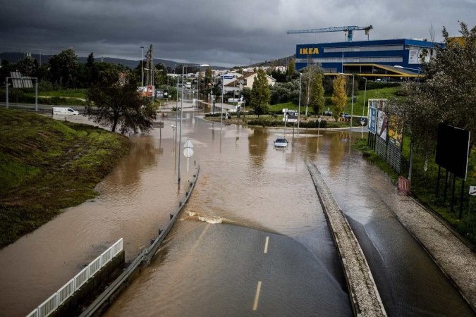 This photograph taken on December 13, 2022 shows a car abandoned in the middle of a flooded street, in Frielas, outskirts Lisbon on December 13, 2022. (Photo by CARLOS COSTA / AFP)        -  (crédito:  AFP)